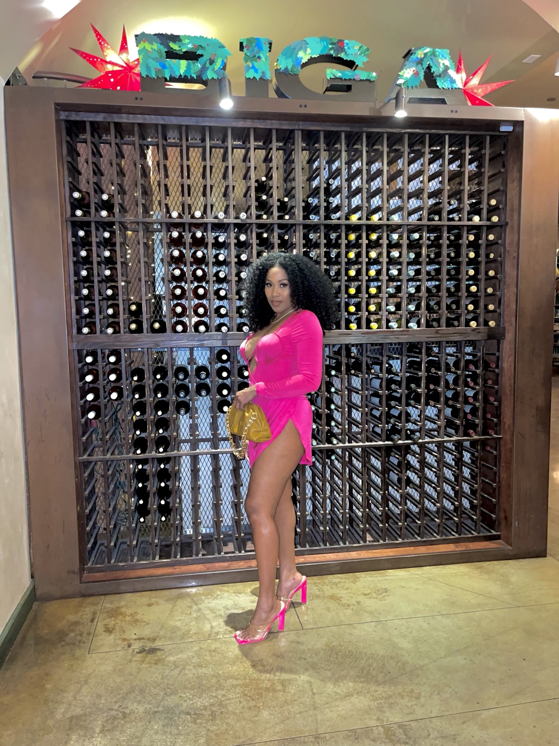 Natural curls with a bright pink dress in a full-length photo